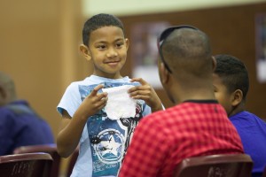 A boy shows his father a piece of paper at Mosaic's "Father and Child Day."