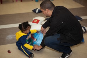 A father helps his young child read a book at Mosaic's "Father and Child Day."