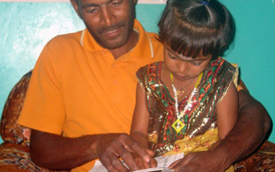 A father and his daughter read from a book in Sri Lanka.