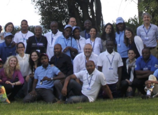 An outdoor group photo from the MenCare+ partner meeting in Rwanda