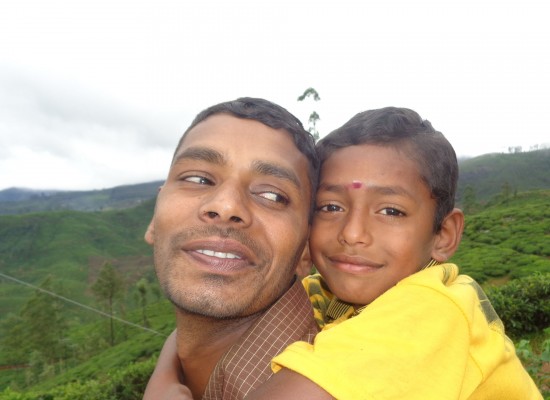 A close-up of a man giving his son a piggy back ride in Sri Lanka.