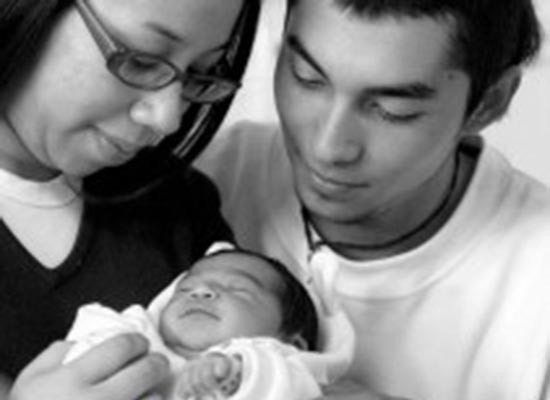 A couple holds their newborn child in Chile