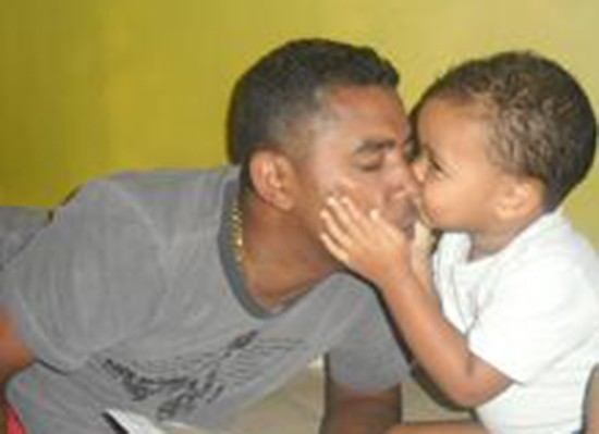 Marcio's son plants a kiss on his father's cheek