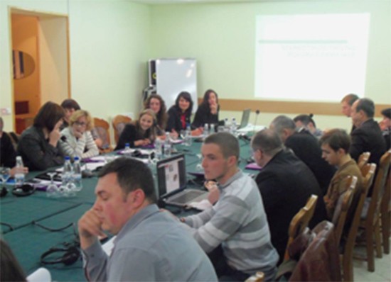 Participants at a domestic violence prevention workshop in Moldova sit around a conference table