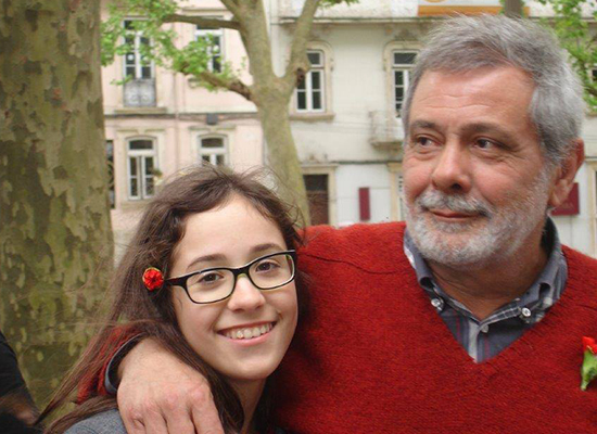 A man puts his arm around his daughter's shoulder in Portugal.