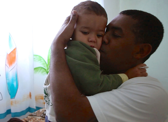 Marcio holds his young son in a still from "MenCare Short: Brazil."