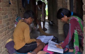 Ram Kumar cleans his home while his children study.