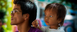 A father and child look into the distance.