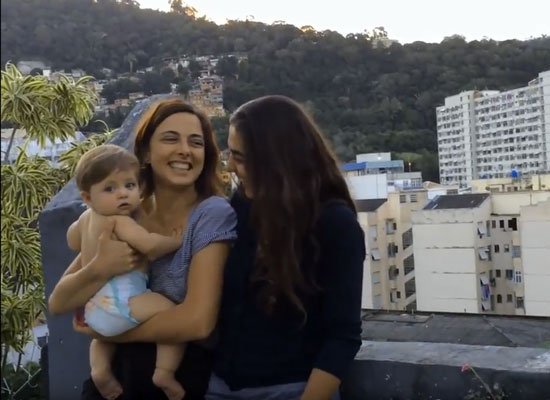 Carol and Kika holding their infant daughter Tereza in Rio de Janeiro.