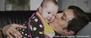 A father holds a baby. Photo: Johan Bävman / mencare.swiss.