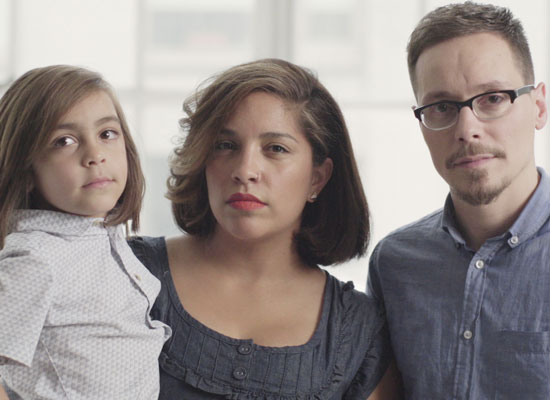 A man, a woman, and a child look at the camera in a still from "America's Dads."