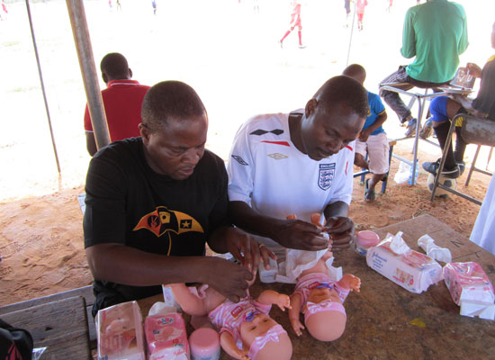 Two men learn to change diapers in South Africa.