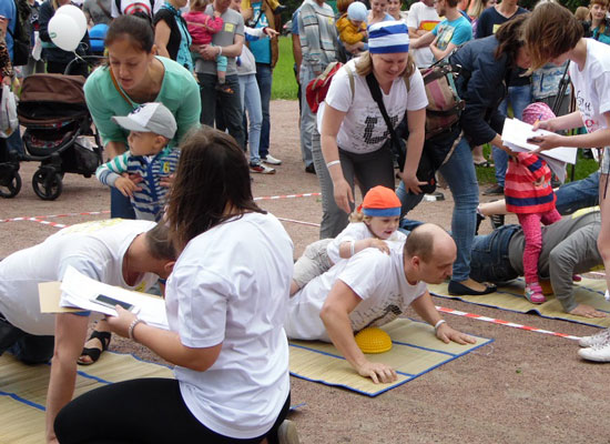 Parents and children play games outside.