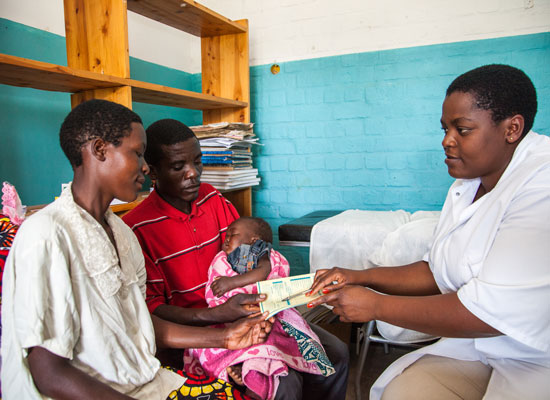 A couple and child with a health professional in Rwanda. Photo by Perttu Saralampi for Equimundo.